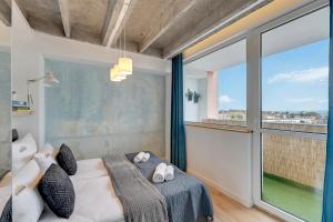 a bedroom with a bed and a large window at Gdynia z widokiem na morze by Downtown Apartments in Gdynia