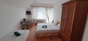 a small bedroom with two beds and a window at ALMI - penzion - pizzerie in Staré Splavy