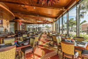 un restaurante con mesas, sillas y ventanas grandes en King Luis - B en Galveston