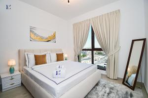 - une chambre blanche avec un grand lit et une fenêtre dans l'établissement Contemporary 2BR Gem in Madinat Jumeirah - RAH, à Dubaï