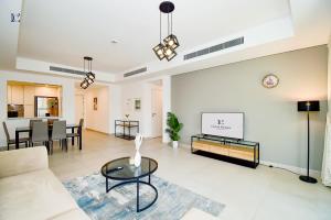 ein Wohnzimmer mit einem Sofa und einem Tisch in der Unterkunft Contemporary 2BR Gem in Madinat Jumeirah - RAH in Dubai