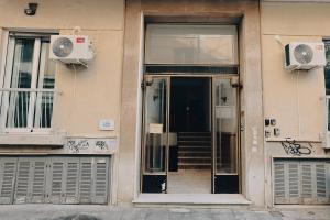 una entrada a un edificio con una puerta de cristal en Apollo 2 bd jacuzzi suite en Athens