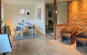 comedor con mesa, sillas y pared de ladrillo en 2 Bedroom Amazing Home In rkelljunga, en Orkelljunga