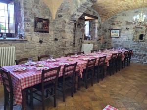 - une longue table dans une pièce en pierre avec un tissu de table rose dans l'établissement Mas Postius, à Muntanyola