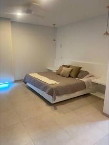 een slaapkamer met een bed in een witte kamer bij casa de descanso pto velero in Barranquilla