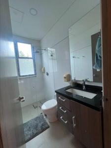 W łazience znajduje się toaleta, umywalka i lustro. w obiekcie casa de descanso pto velero w mieście Barranquilla