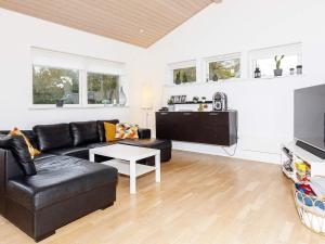 sala de estar con sofá de cuero negro y mesa en 8 person holiday home in Hals en Hals