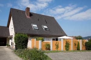una casa con techo negro y valla en Ferienwohnung Dr Saretz, en Bodman