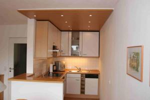 Una cocina con gabinetes blancos y un fregadero. en Ferienwohnung Dr Saretz, en Bodman 3 fotos más