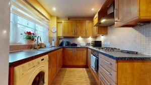 uma cozinha com um lavatório e uma máquina de lavar louça em Impeccable 4-Bed House in London em Londres