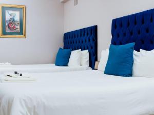 A bed or beds in a room at Ngwenya City Hotel