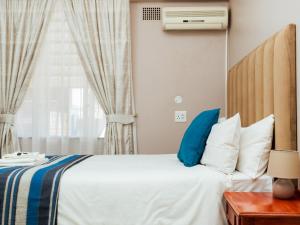 Postel nebo postele na pokoji v ubytování Ngwenya City Hotel