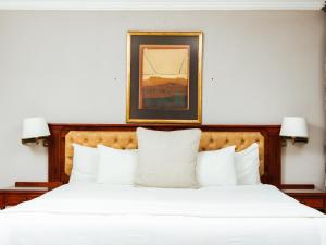 A bed or beds in a room at Ngwenya City Hotel