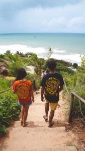 two people walking down a path towards the beach at SAMO Hostel in Pipa