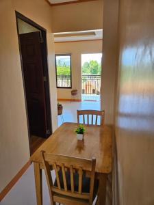 a dining room with a wooden table and chairs at Moalboal Cay in Moalboal