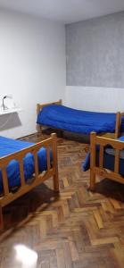 2 camas con sábanas azules en una habitación en Casa Facu en Godoy Cruz