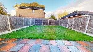 a backyard with a wooden fence and green grass at Impeccable 4-Bed House in London in London