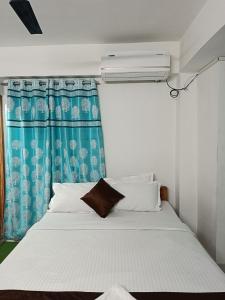 a bed in a room with a blue curtain at HOTEL ATITHI GRAND in Guwahati