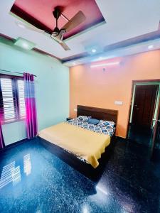 ein Schlafzimmer mit einem Bett und einer Decke in der Unterkunft Sahara premium family homestay in Mysore