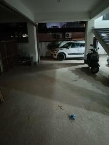 a white car parked in a garage with a scooter at HOTEL ATITHI GRAND in Guwahati