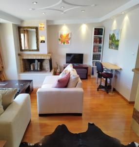 a living room with white furniture and a fireplace at sunlight loft in Kastoria