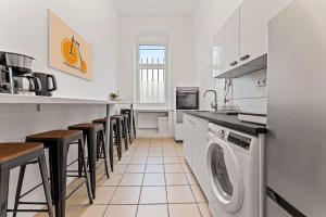 a kitchen with a washing machine and some stools at Neues zentrales Apartment,10 Betten,vollmöbliert, Wifi in Berlin