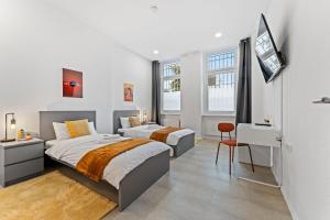 a white bedroom with two beds and a desk at Neues zentrales Apartment,10 Betten,vollmöbliert, Wifi in Berlin