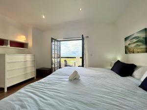 a bedroom with a large white bed with a window at LINDA PRAIA in Consolação