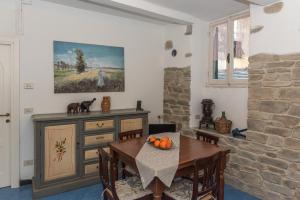 a dining room with a table and a stone wall at Casa del Borgo by Arbaspàa in Riomaggiore