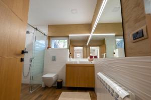 y baño con ducha, aseo y lavamanos. en 1-Bedroom Apartment with Balcony, en Ledine