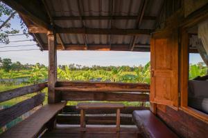 a wooden cabin with a bench and a window at Suk Sabai Homestay in Sukhothai