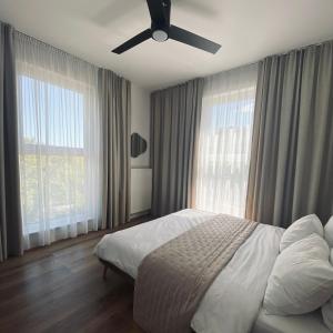a bedroom with a bed and a ceiling fan at Tuyo Apartments Bokserska in Warsaw