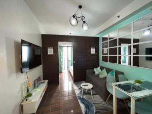 een woonkamer met een bank en een tafel bij Cozy Condo Apartment in Makati / Manila with mall, restaurants, groceries, pool, netflix, disney+ and more in Manilla