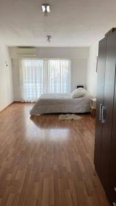 1 dormitorio grande con 1 cama y suelo de madera en Ruffus´s Apple Rosario, en Rosario