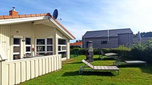 a house with a fence and a bench in the yard at Kapitänshus-Strandpark 24 in Grömitz