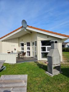 ein Haus mit Grill im Hof in der Unterkunft Kapitänshus-Strandpark 24 in Grömitz