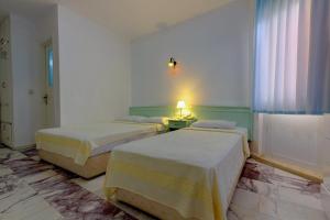 A bed or beds in a room at Mandalinn Hotel