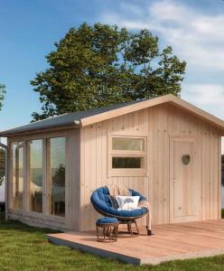 a shed with a chair in front of it at Sjugare Gård Glamping in Leksand