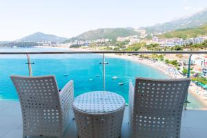 einen Tisch und Stühle auf einem Balkon mit Blick auf den Strand in der Unterkunft Hotel Ponta Nova in Budva