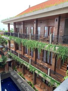 an apartment building with a courtyard and a swimming pool at The Ganesha Homestay in Canggu