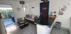 uma cozinha com um balcão preto e um sofá em Mas bleu île des pêcheurs em Le Barcarès