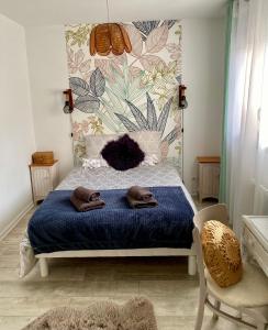 een slaapkamer met een bed met twee handdoeken erop bij L’appart Duplex Bis in Le Havre