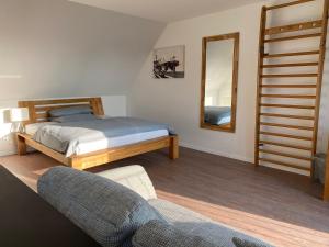 1 dormitorio con cama, silla y espejo en MEINpartments - Full service living en Wolfsburg