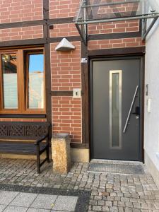 a black door on a brick building with a bench at MEINpartments - Full service living in Wolfsburg