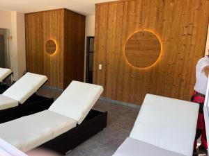 Zimmer mit 3 weißen Stühlen und Holzwänden in der Unterkunft Morada Hotel Alexisbad in Alexisbad