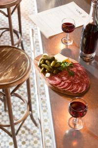 una mesa con un plato de comida y dos copas de vino en Hotel Beaulieu Lyon Charbonnières, en Charbonnières-les-Bains