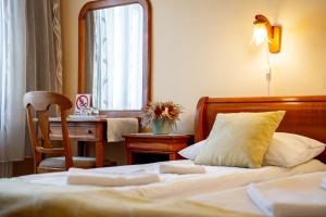 オドルヘユ・セクイエスクにあるLilla Panzióのベッドルーム(ベッド1台、デスク、鏡付)