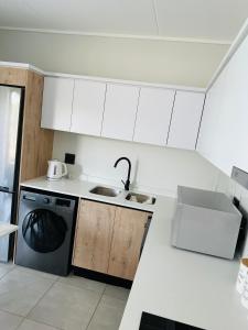 a white kitchen with a sink and a dishwasher at Lagoon facing The Blyde in Pretoria