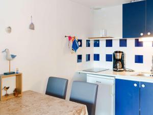 グリュイッサンにあるVilla Gruissan, 1 pièce, 4 personnes - FR-1-409-52のキッチン(テーブル、椅子、青いキャビネット付)