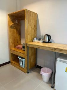 a wooden shelf in a kitchen next to a refrigerator at CheeVa Beach Resort in Baan Tai
